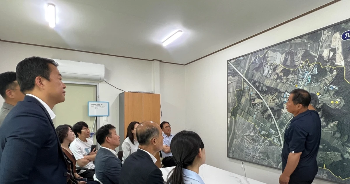 2025년 여주 구양리 마을 태양광 사업 견학에서 관계자들이 마을 부지 지도를 보며 설명을 듣는 모습
