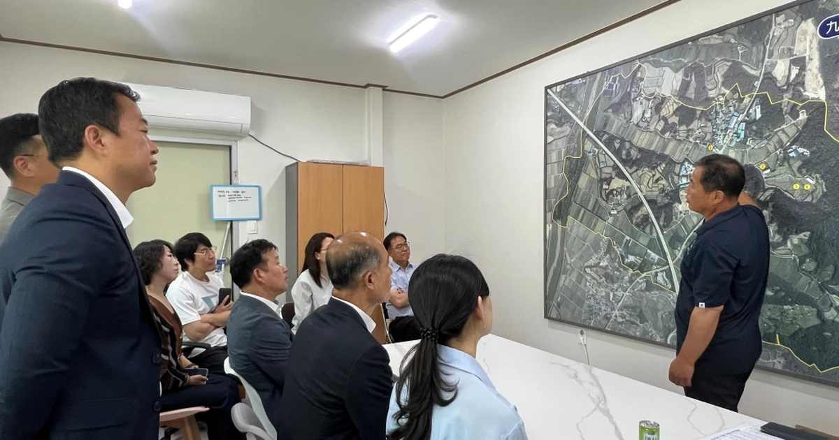 2025년 여주 구양리 마을 태양광 사업 현장 방문에서 관계자들이 부지 지도를 보며 설명을 듣는 모습